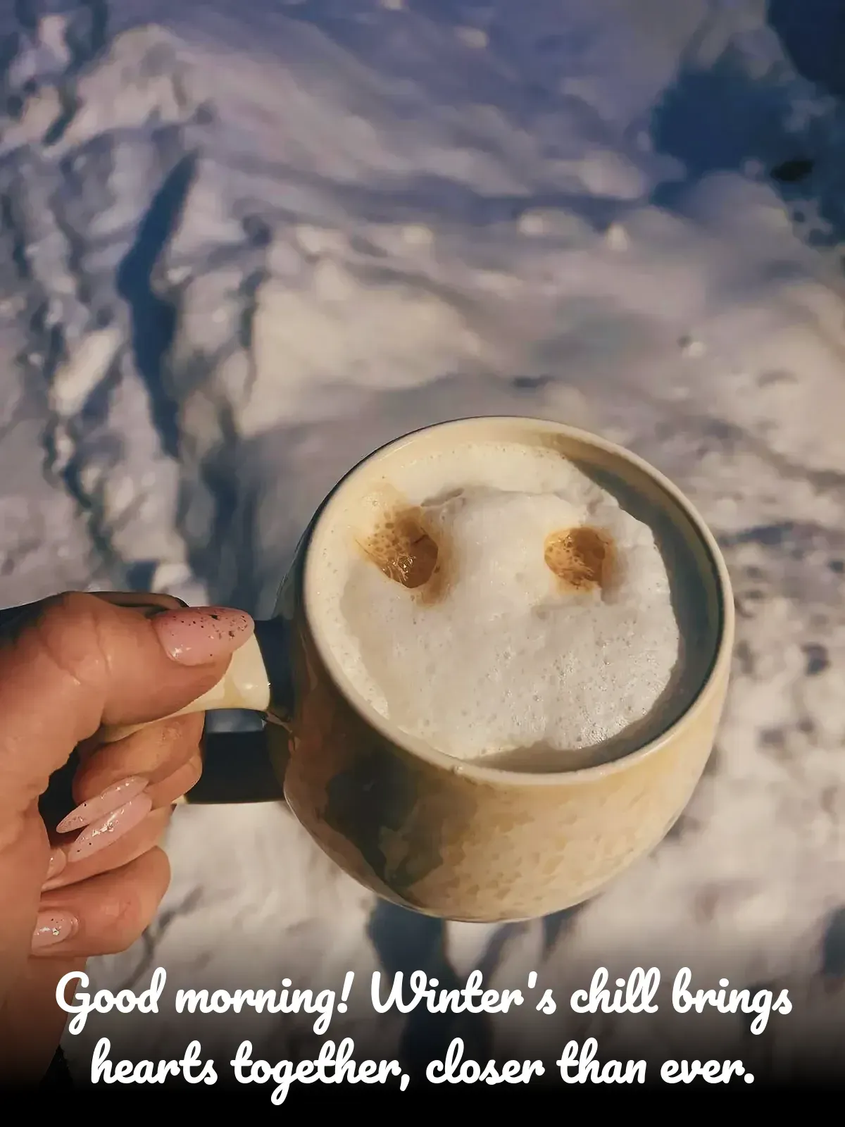 A hand holding a coffee mug with a unique design on it, surrounded by winter scenery.