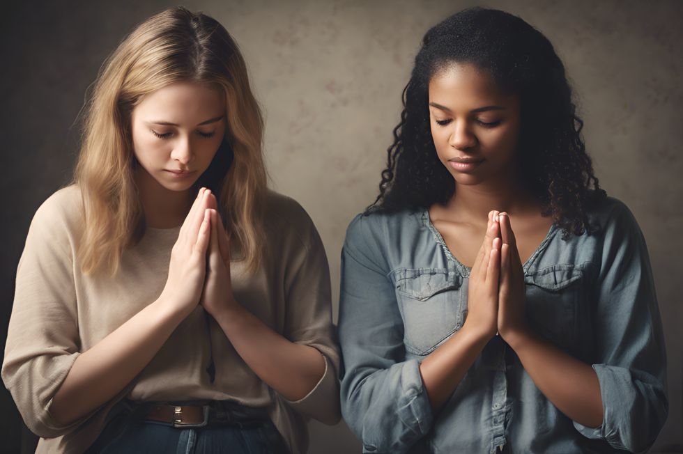 Two female friends praying